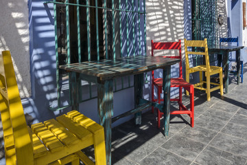 Fototapeta na wymiar Bright, Colorful Chairs and Tables Outside of a Restaurant in Todos Santos, Mexico Entice Tourists and Locals Alike 