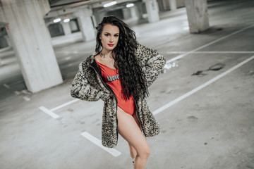 young sexy woman rollerskating in an urban looking garage and posing in a hipster like matter