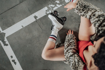 young sexy woman rollerskating in an urban looking garage and posing in a hipster like matter