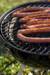 Grilling sausages outside on a barbecue grill