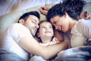 Portrait of happy family in bed at morning.