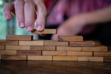 hand stacking wood block. growth, success & development in business
