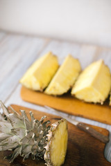 Sliced fresh pineapple on a wooden background in sunlight