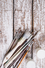 Brushes on a wooden painted white background.