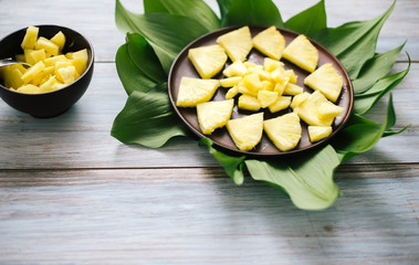 Sliced fresh pineapple in a bowl on the leaves