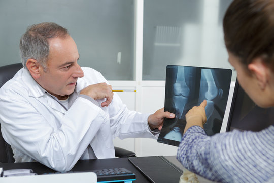 male doctor showing x rays to her patient in office