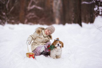 Fototapeta na wymiar Sweet girl and a dog with flowers spring day in the forest for the holiday
