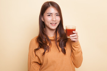 Young Asian woman drink tomato juice.