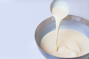 Fototapeta na wymiar Kneading dough for pancakes. Batter for pancakes is poured from a large spoon