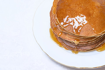 Pancakes with honey on white background.