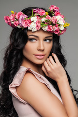 Fototapeta premium Cute Female Face with Flowers. Pretty Woman with Makeup and Floral Hairstyle