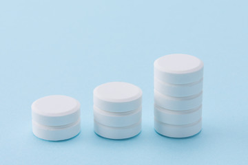 stack of white round pills as column bar graphs