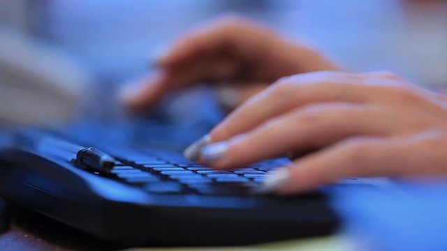 Woman typing text on keyboard close up