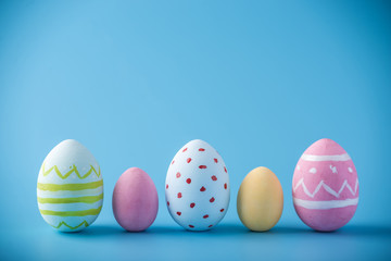 Colorful Easter eggs hand painted on a blue background. Holiday spring card