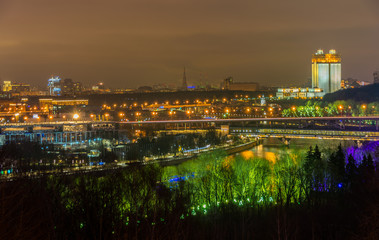Fototapeta na wymiar Nightview of Moscow city with Luzhniki stadium, the Russian Academy of Sciences building, the Railway bridge over the Moskva river and open air underground station Vorobyovy Gory. Evening illumination