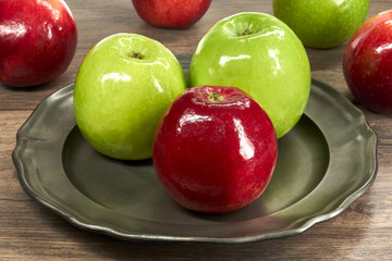 Czerwone i zielone jabłka na metalowym talerzu