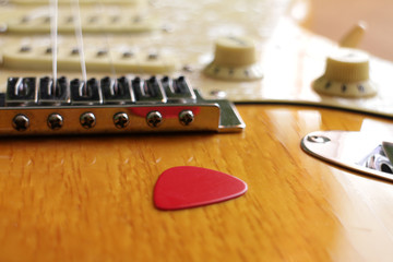 Electric guitar bridge, pick, volume and tone knobs