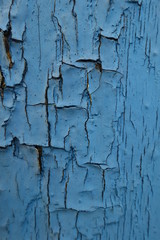 Closeup of peeling paint on old blue wooden wall