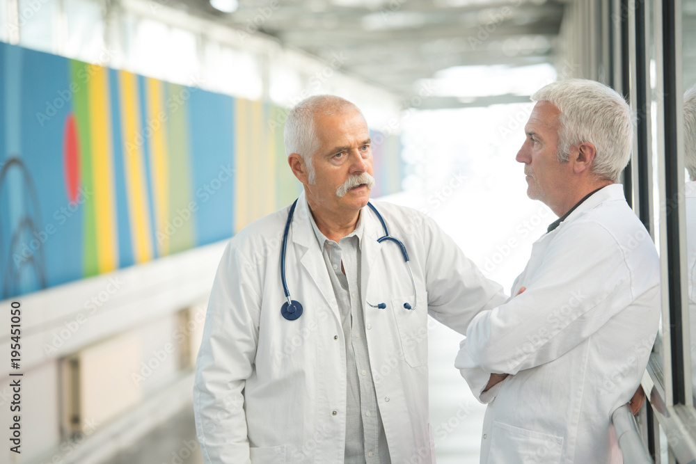 Wall mural two senior doctors talking in hospotal corridor