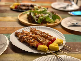 Chicken Barbecue in paper white dish on vintage table . Dinner party .