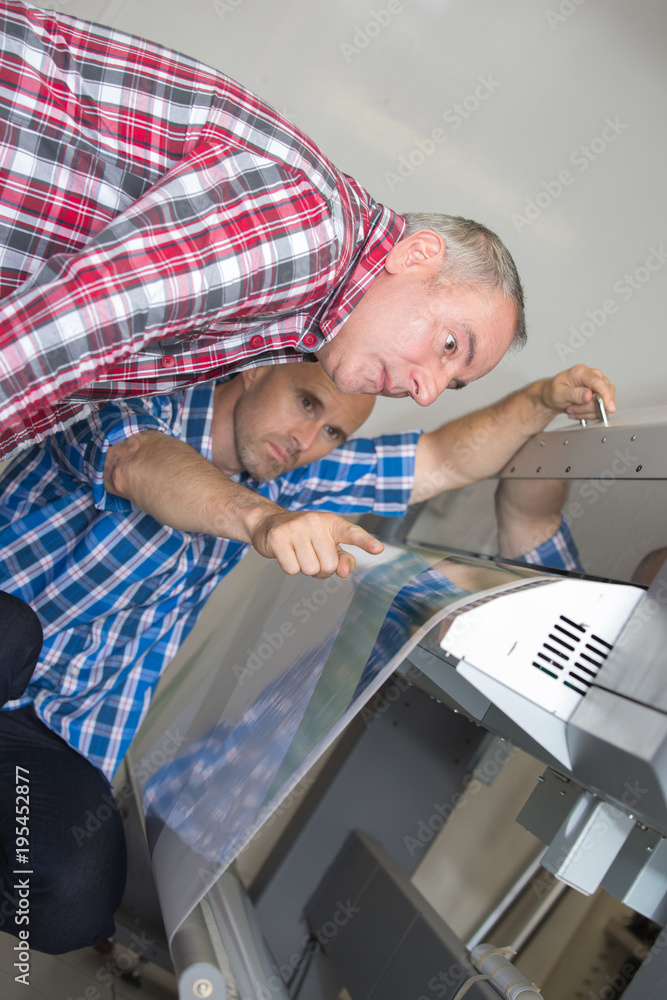 Wall mural men examining machine