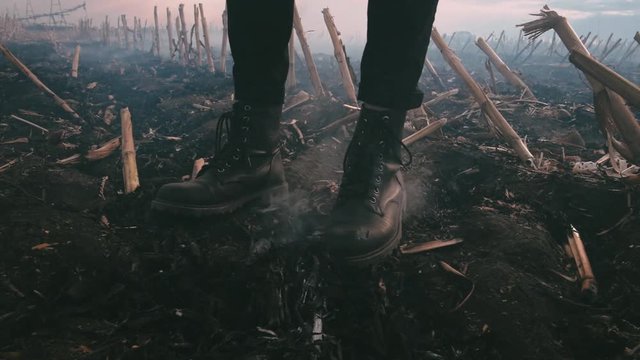 Postapocalypse. Girl on the scorched field. Boots