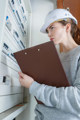 female electrician checking fuse box