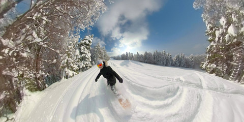 Freeride snowboard girl riding fresh powder snow in sunny mountain ski resort