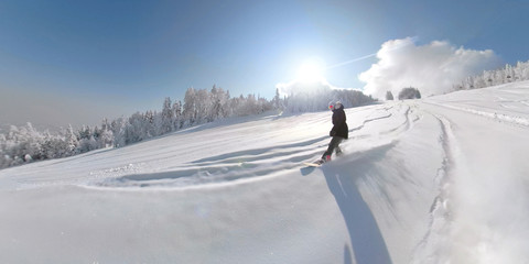 LENS FLARE Young snowboarder woman riding fresh fallen snow in empty ski resort