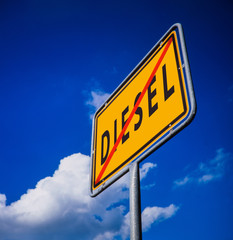 Obraz premium Dieselfahrverbote, Konzeptfoto Ortsschild vor blauem Himmel mit durchgestrichener Schrift Diesel