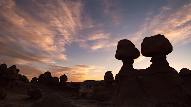 Colorful sunset time lapse in Goblin Valley with hoodoos silhouetted against the sky in Utah.
