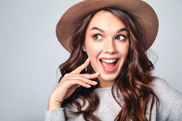 Portrait of young stylish laughing girl model in gray casual summer clothes in brown hat with natural makeup isolated on gray background. Looking at camera