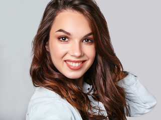 Naklejka premium Portrait of young stylish laughing girl model in colorful casual summer clothes with natural makeup isolated on gray background. Looking at camera