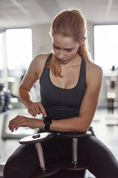 Junge Frau mit Smartwatch beim Hanteltraining