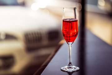 Red Cocktail in Champagne Glass near the Window in the Bar with Amazing Blurred Background, Free Space for Text