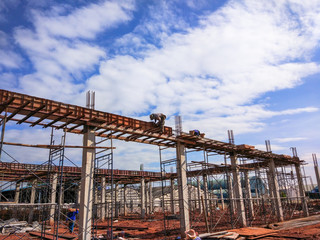 Fototapeta na wymiar Worker sit on a building under construction site with steel work and wooden scaffolding. he build flyover without safety helm and belt.