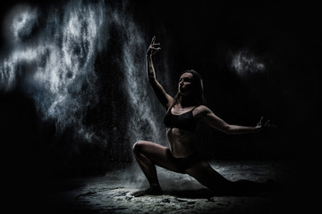 Naklejka premium Girl dansing with flour on black background