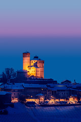 Serralunga castle during a cold winter night with snow in langhe region, Italy