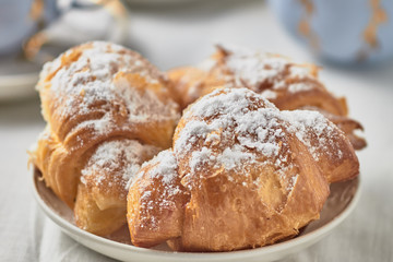 Croissants with jam on a plate and coffee on a white background.