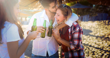 Group of young friends laughing and drinking beer