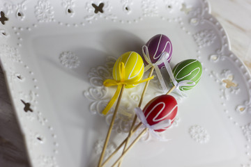 A composition of colorful eggs on a white wooden background