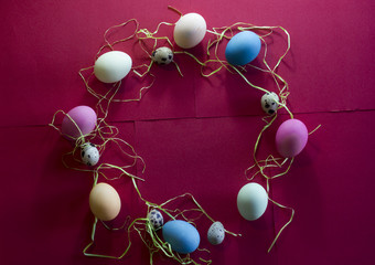 A composition of colorful eggs on a red paper background
