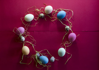 A composition of colorful eggs on a red paper background