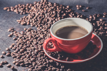coffee in red cup and coffee beans are the background.