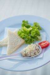 Healthy toast sandwich with lettuce, ham, cheese and tomatoes on a white plate
