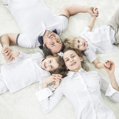 concept of family happiness: happy family relaxing on the carpet on Sunday