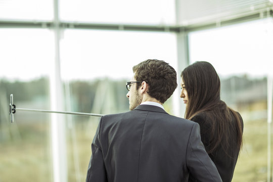 members of the business team doing a selfie while standing near window in office