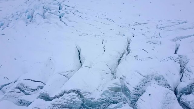 Aerial view of crevasses with visible layers of ice. Cracked glacier from above.