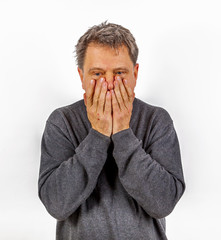 astonished anxious man has hands in the face