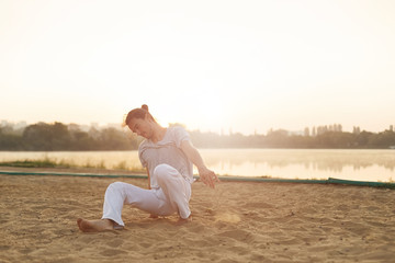 Athletic capoeira performer making movements on the beach